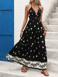 Detailed view of a retro black halter maxi dress with white floral print for summer.