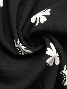 Macro view of black fabric with white floral print detailing for a summer halter dress