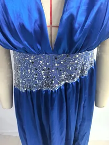 Close-up of a blue satin evening gown with intricate sequined mesh waist detail.