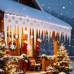 White foam Christmas icicle lights hanging from a snowy cabin roof eaves at night.