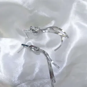Detailed macro view of elegant silver tassel drop earrings with sparkling stone accents.