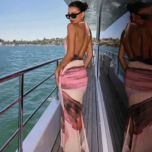 Back view of elegant pink tie-dye halter maxi dress with backless design and split hem
