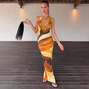 Elegant halter neck maxi dress featuring a vibrant abstract orange and brown print.