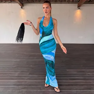 Full-length view of a model wearing a sexy blue abstract wave print halter maxi dress.