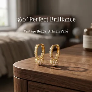 Close-up of luxury golden pavé hoop earrings with intricate artisan detail.