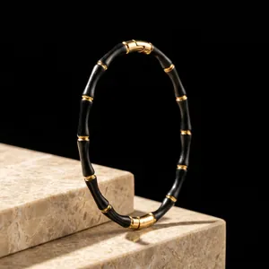 Elegant black and gold stainless steel bamboo joint bangle with a secure click clasp