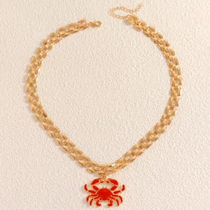 Golden watch-strap link necklace featuring a detailed vibrant red crab pendant charm