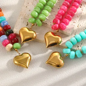 Dettaglio macro di ciondoli a cuore in oro 18 carati con collane di perle in resina