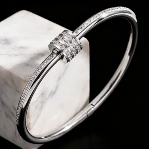 Elegant silver stainless steel bangle with sparkling pavé rhinestones on marble