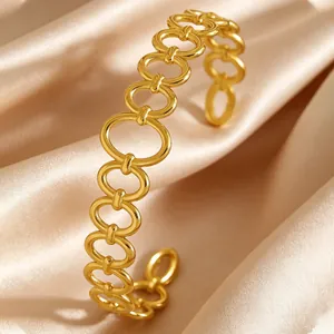 Close-up of vintage gold stainless steel oval link open cuff bracelet on silk