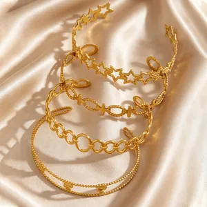 Detailed view of four stackable gold-plated stainless steel bracelets on silk background