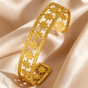 Detailed macro shot of vintage gold stainless steel cuff bracelet with hollowed star patterns
