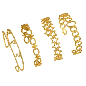 Macro detail of four vintage gold stainless steel bracelets with star and cross designs