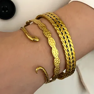Detail view of gold-plated stainless steel snake and braided stackable bracelets on wrist