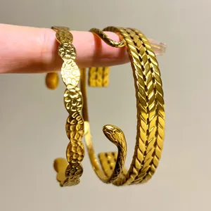 Close-up of gold-plated stainless steel bangles with snake and woven patterns