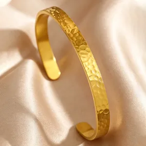 Detailed macro view of the vintage hammered texture on a gold stainless steel cuff bracelet