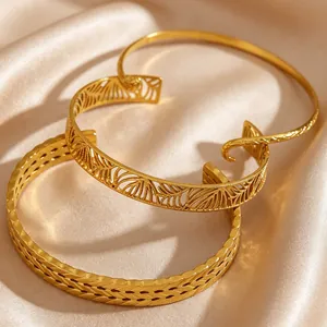 Close-up of gold stainless steel bracelets featuring hollow leaf and woven patterns.