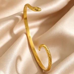 Detailed macro view of the vintage gold snake head design on a stainless steel bangle