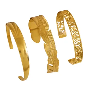 Detail view of three vintage gold-plated stainless steel bangles with leaf patterns