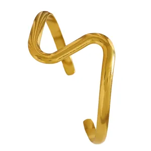 Close-up of a vintage-style gold wavy stainless steel cuff bracelet with textured detail