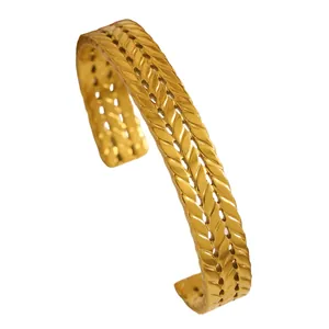 Close-up of a bohemian vintage gold stainless steel cuff bracelet with woven wheat pattern