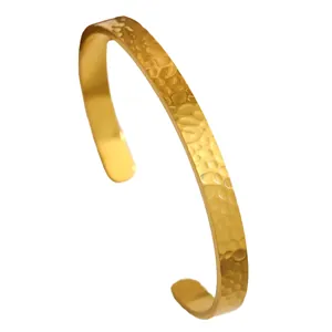 Detailed view of a gold-plated stainless steel cuff bracelet with hammered texture.