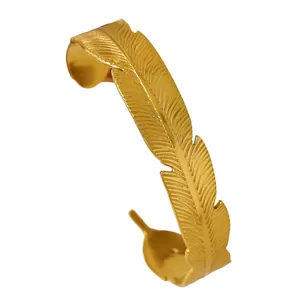 Detailed macro view of vintage golden stainless steel feather shaped cuff bracelet