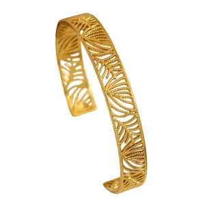 Intricate leaf cutout pattern on a gold-plated vintage stainless steel cuff bracelet