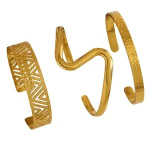 Detail showing three distinct styles of gold stainless steel bracelets with textures