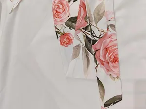 Primo piano dell'elegante stampa a rose rosa su tessuto bianco per un abito lungo donna