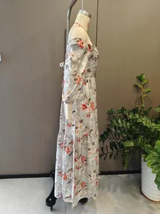 Elegante vista laterale di un abito lungo a fiori con spalle scoperte su manichino.