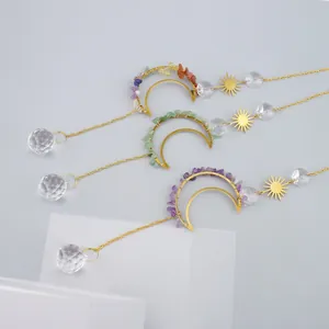 Detailed view of three crystal sun catchers with moon motifs and natural stone chips