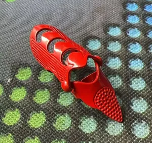 Detailed view of a red punk style articulated finger claw ring with a textured pointed tip