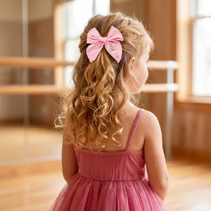 Pink embroidered ballerina bow hair clip for girls in a dance studio setting
