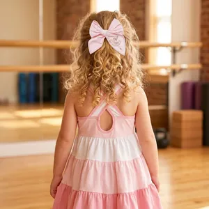Close-up of a pink ballet girl embroidered bow hair clip on a young girl's curly hair