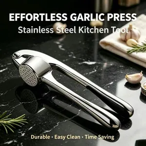 Durable stainless steel manual garlic press kitchen tool on black marble surface.