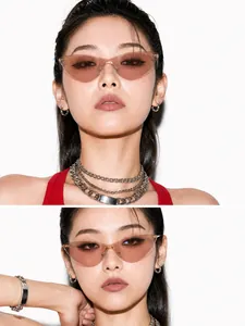 Close-up of vintage rimless cat-eye sunglasses with transparent pink lenses on model.