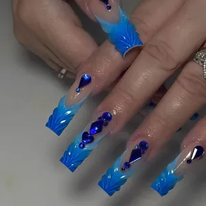 Close-up of handmade press-on nails with blue gradient, 3D texture, and blue gems.