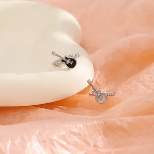 Detailed view of vintage punk style black and white guitar-shaped ear clips with crystals.