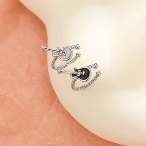 Close-up macro shot of retro punk style guitar shaped ear cuffs in black and white finish