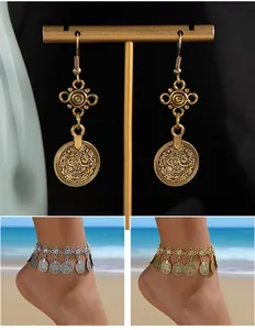 Detail view of Bohemian vintage coin earrings and anklets in gold and silver finish.