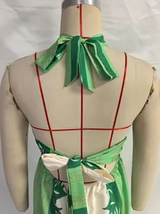 Dettaglio posteriore di un abito lungo verde con scollo all'americana e fiocco.