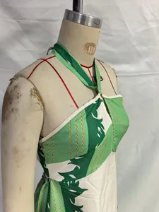 Dettaglio di un abito lungo halter con stampa tropicale verde e bianca su manichino.