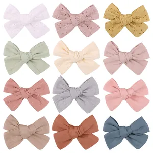 Detailed view of handmade child hair bow clips in various colors and embroidery textures