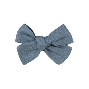 High-detail macro view of a dusty blue handmade linen fabric bow hair clip for girls