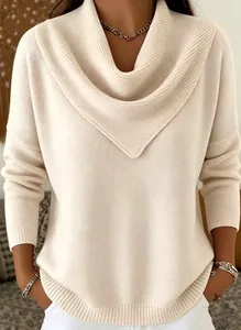 Close-up of elegant cream knit sweater featuring unique draped v-neck collar detail.