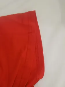 Vue rapprochée des détails de couture sur l'ourlet d'une robe rouge sexy en maille