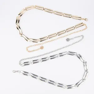 Detailed view of elegant gold and silver metal waist chains with floral charm and link design