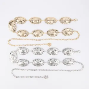 Detail view of gold and silver bohemian metal waist chains with oval textured plates