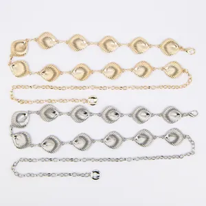 Close-up detail of bohemian shell-shaped metal waist chains in gold and silver finishes